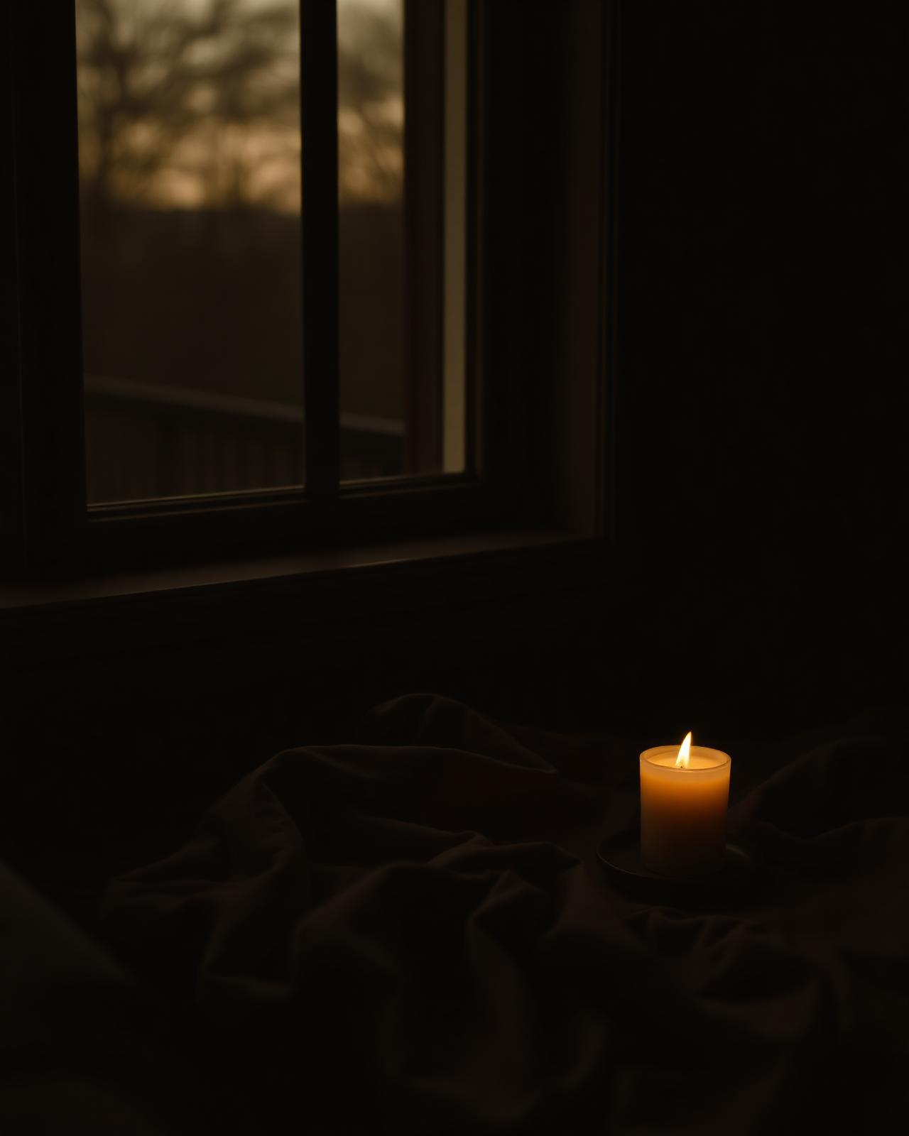 Warm evening light across a folded blanket by a window